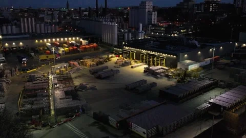 Industrial Yard with Stacked Materials and City Lights at Nightfall Vídeos de archivo 332444579