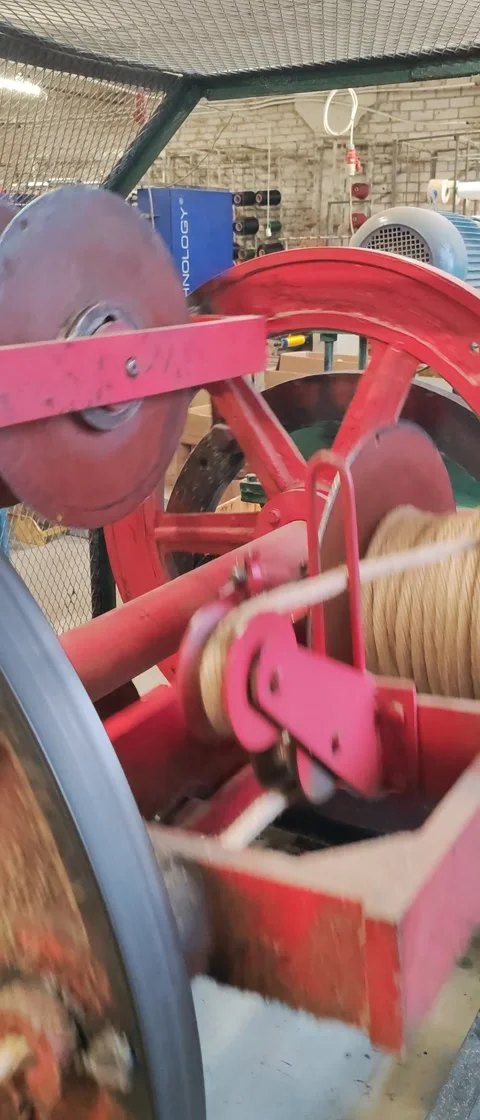 Industrial yarn winding machine in motion with vibrant red wheels Stock Footage 293147274