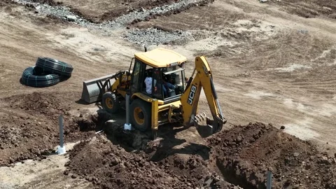 An industrial yellow backhoe loader lifting its mechanical shovel arm after Stock Footage 337479968
