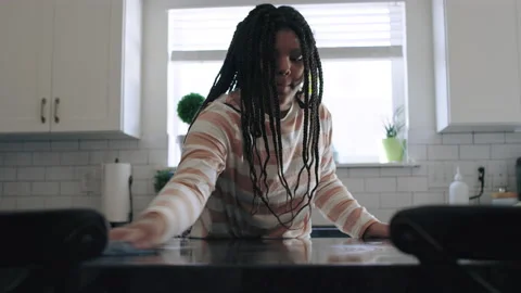Industrious and hard working black teen girl cleans countertop while baking 8K Video stock 194469612