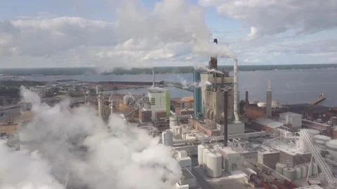 Industry Complex Next to Shore shown from cloudy Sky with Chimneys and Smoke Video stock 135932599
