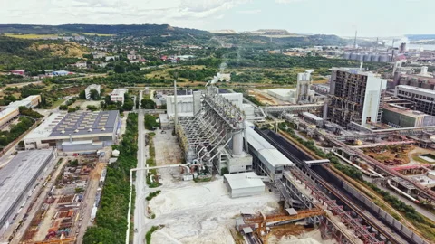 Industry site displays large facilities and machinery near mountains and Video stock 340962957