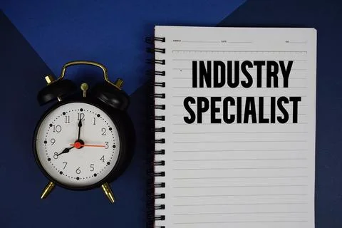 Industry Specialist text written on notepad with alarm clock on blue backgrou Stock Photos