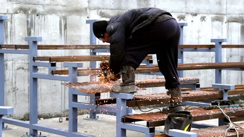 Industry. A worker at the site works as a tool for metalworking. Around a lot of Video stock 180598778