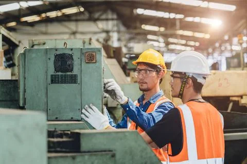 Industry worker working together training young new machine operator staff in Stock Photos