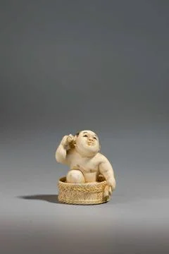 ï»¿Netsuke in the shape of a boy bathing in a tub. unknown, sculptor Copyr Stock Photos