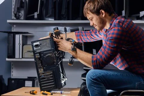Inexperienced guy learning to repair a computer Stock Photos