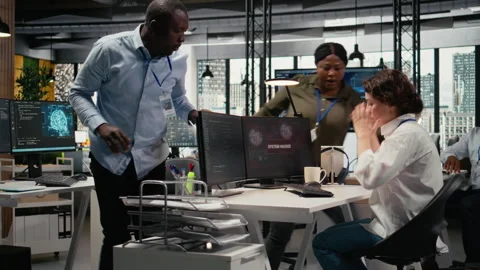 Inexperienced intern in office requests help from team to fix hacking attempt Stock Footage 323030391