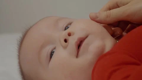 Infant actively mp4ing hands and legs and mother caresses face. Stock Footage 302452350