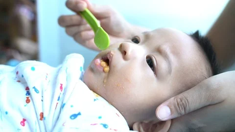Infant asian boy try eating food feed by hand of mom Stock Footage 108389141