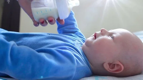 Infant baby crying when get bottle with infant milk from his mothers hands in Stock Footage 71659489