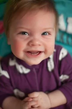 Infant in bed with first teeth smiling Stock Photos