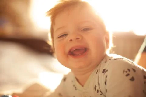 Infant in bed with first teeth smiling Stock Photos