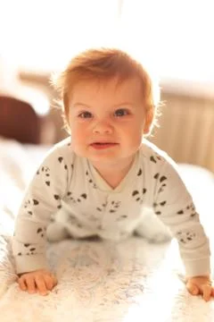 Infant in bed with first teeth smiling Stock Photos