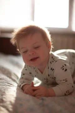 Infant in bed with first teeth smiling Stock Photos