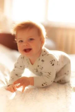 Infant in bed with first teeth smiling Stock Photos