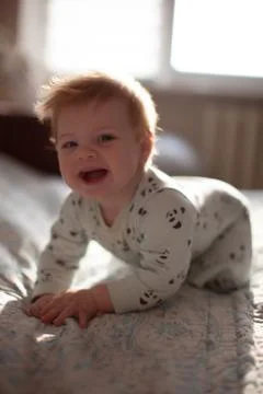 Infant in bed with first teeth smiling Stock Photos