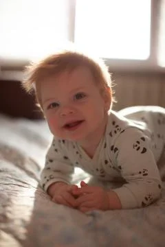 Infant in bed with first teeth smiling Foto stock