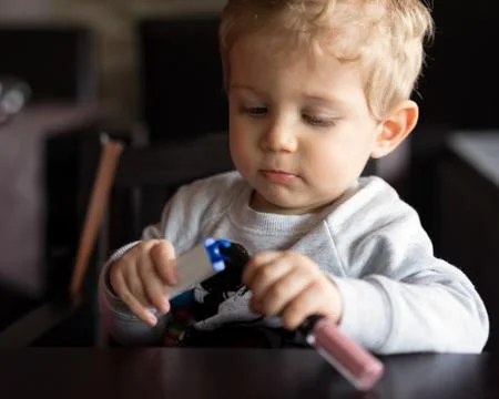 Infant boy plays with objects at restaurant 库存照片