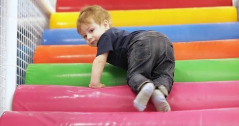 Infant boy plays on a plastic slide 스톡 동영상 125843367
