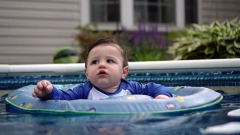 Infant boy splashing in a pool float Stock-Footage 104659307