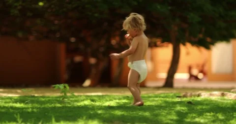 Infant child walking outside in the sunl, Stock Video