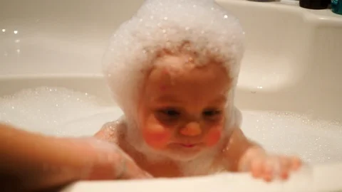 Infant Covered in Bubbles Close Up Playing and Smiling in Bath. A baby with foam Stock Footage 102865234