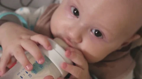An infant eats baby formula from a bottle. Feeding a baby close-up.baby.Baby's h Stock Footage 163660238