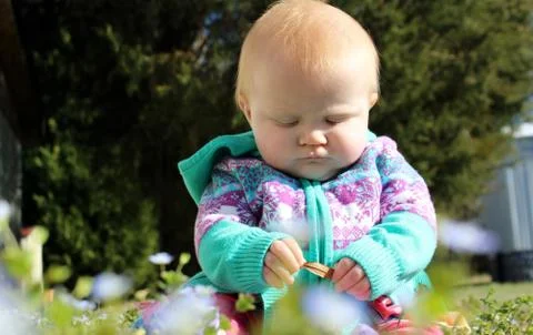 Infant girl in flowers Stock Photos
