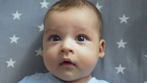 Infant lies on back with open big eyes Stock Footage