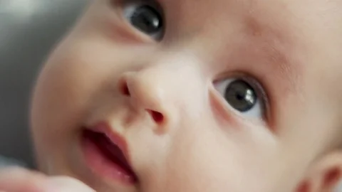 Infant lies on back with open big eyes Vídeos de archivo 76959932