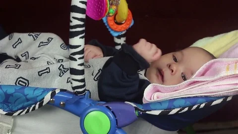 Infant lying in bed and playing. Stockbeeldmateriaal 72793200