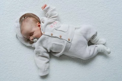 Infant lying on clean white background in minimal style. Fotos de archivo