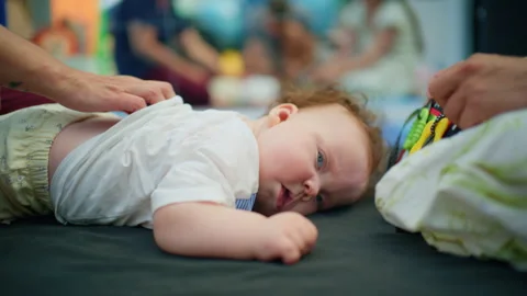 Infant lying on stomach getting professional back massage from therapist, Stock Footage 342861211