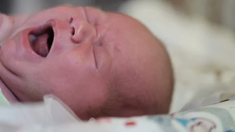 Infant offended and crying. Cute baby boy crying on bed in morning. Stock Footage 124741867