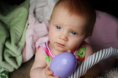 Infant with plastic Easter egg Stock Photos