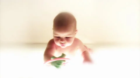 Infant playing with a plastic toy. White background. Stock Footage 44561552