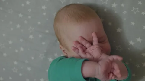 Infant raising hands to cover face Stock Footage 341040638