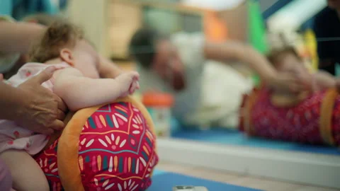 Infant receiving early intervention physical therapy, playing with a toy in 스톡 동영상 343135801