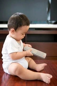 Infant with remote Stock Photos