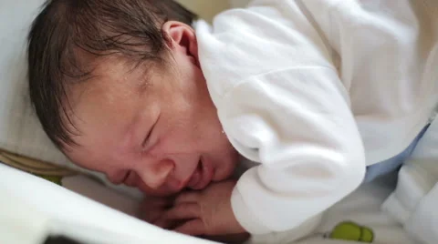 Infant sleeping and try wake up Stock Footage 60095033