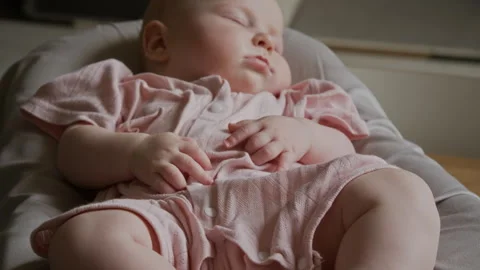 Infant Sleeping Peacefully in Rocking Bouncer Seat at Home Stock Footage 346608342