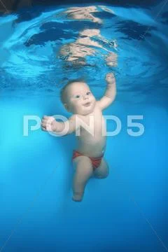 Infant swim under water in the pool Stock Photos