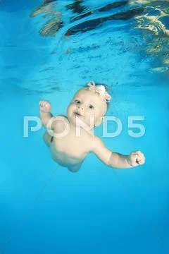 Infant swim under water in the pool Stock Photos