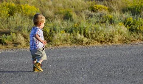 Infant walking with daddy at sunset on path Stock Photos