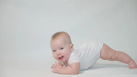 Infant on a white background first attempts at a mobile Stock Footage 237242633