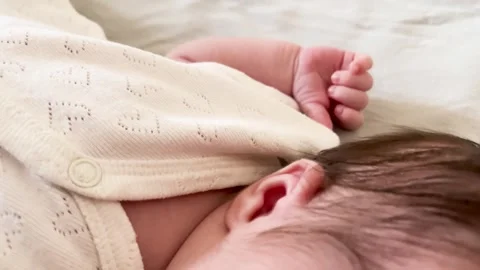 Infant's delicate hand on soft quilted blanket Stock Footage 317496118