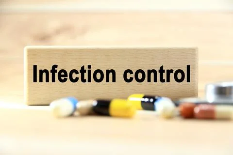 Infection control wording or text on wood block with capsule medicine.Copy .. Stock Photos