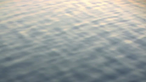 Infinite background of water waves move in lake with sunset reflection colors. Stock Footage 149010971