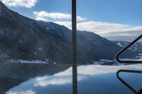 Infinity pool and spa terrace reflect Dolomites peaks in Italy Stock Photos